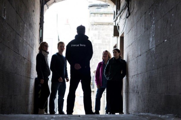 Guide with a group in an Edinburgh Close, Royal Mile, Edinburgh